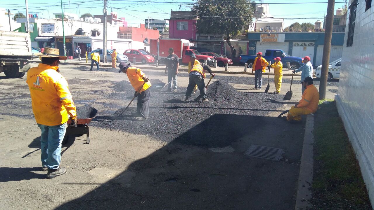 Trabajo de bacheo en estacionamiento del Mercado Benito Juárez