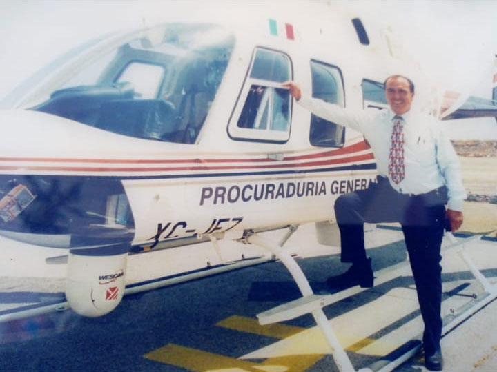 Guadalupe Narciso Pina Cruz cuando era comandante de la policía ministerial posa al pie de un helicóptero adscrito a la dependencia.