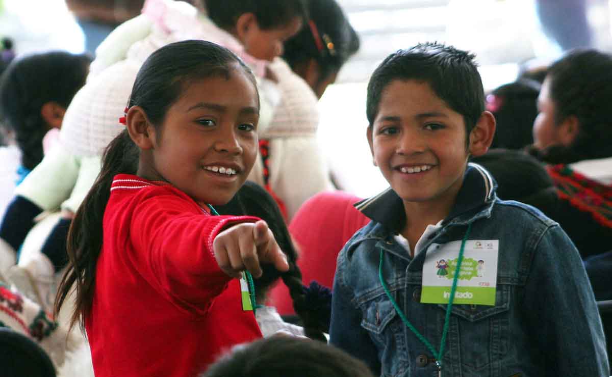 Niños sonriendo frente a la cámara en un evento del gobierno del Edomex. 