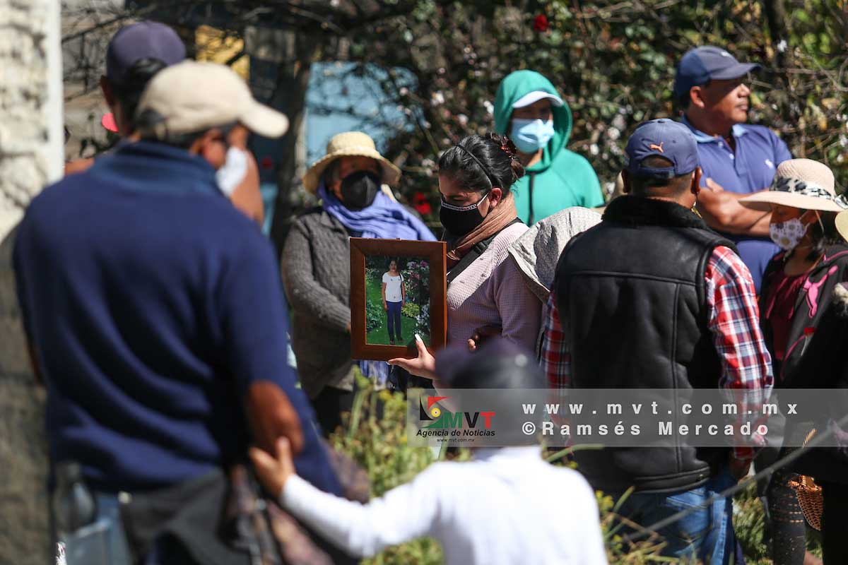 Una mujer muestra la foto de su familiar que fue sepultada esta tarde en Temoaya