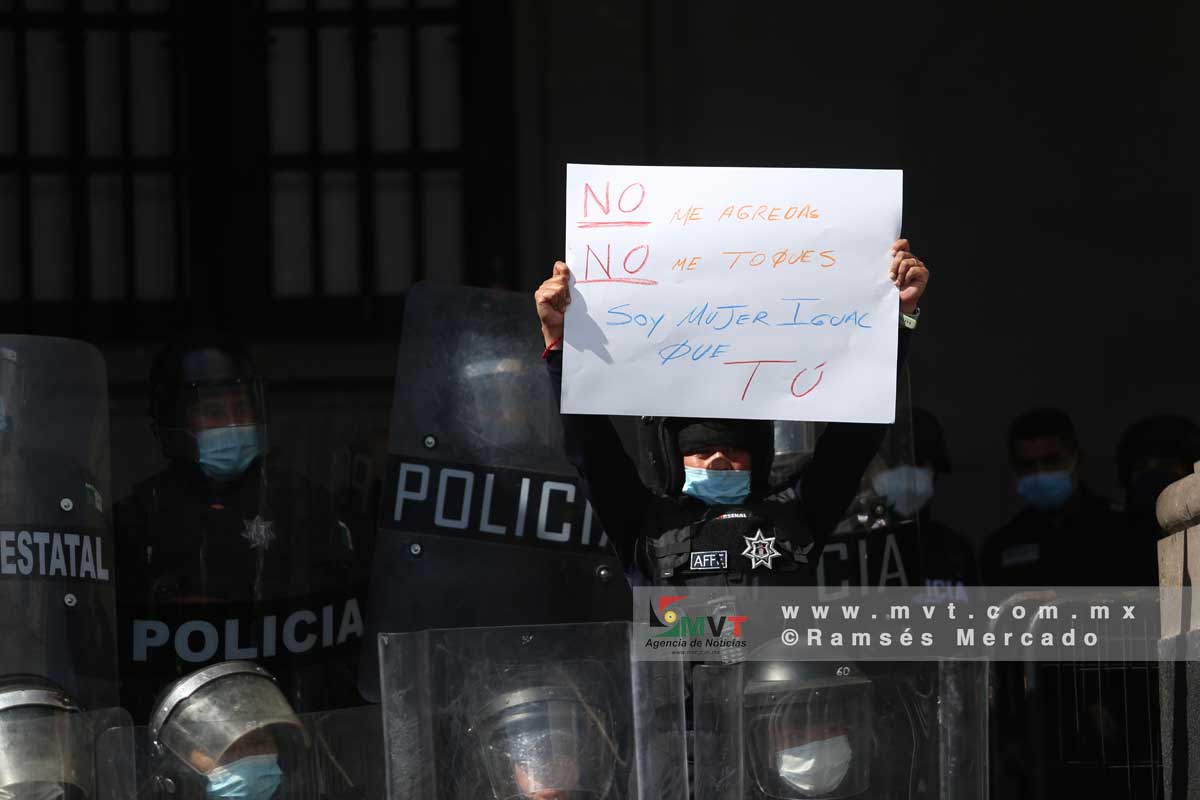 Una mujer policia muestra un mensaje pidiendo lo ser agredida durante la marcha de feministas en Toluca