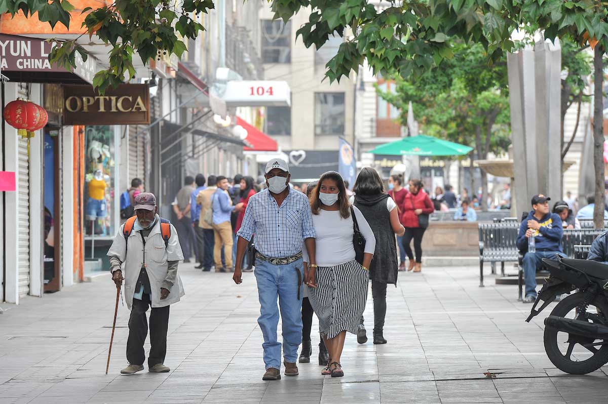Habitantes de Toluca en la ciudad usando cobrebocas en sus actividades diarias