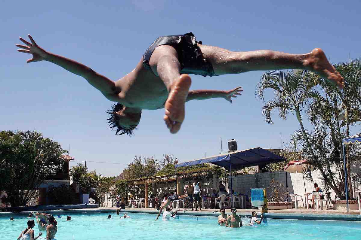 Niños y familias disfrutando de las vacaciones de verano en una alberca