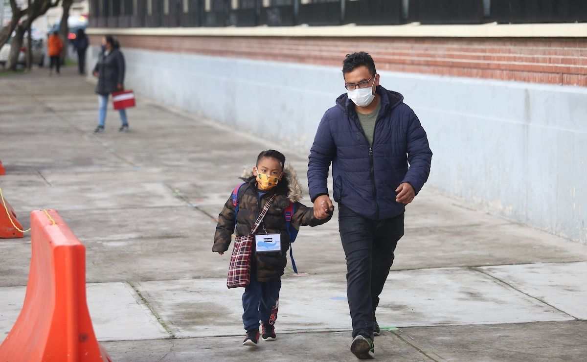 Padre e hijo caminando hacia la escuela como beneficiarios del Seguro de Vida para las Jefas de Familia
