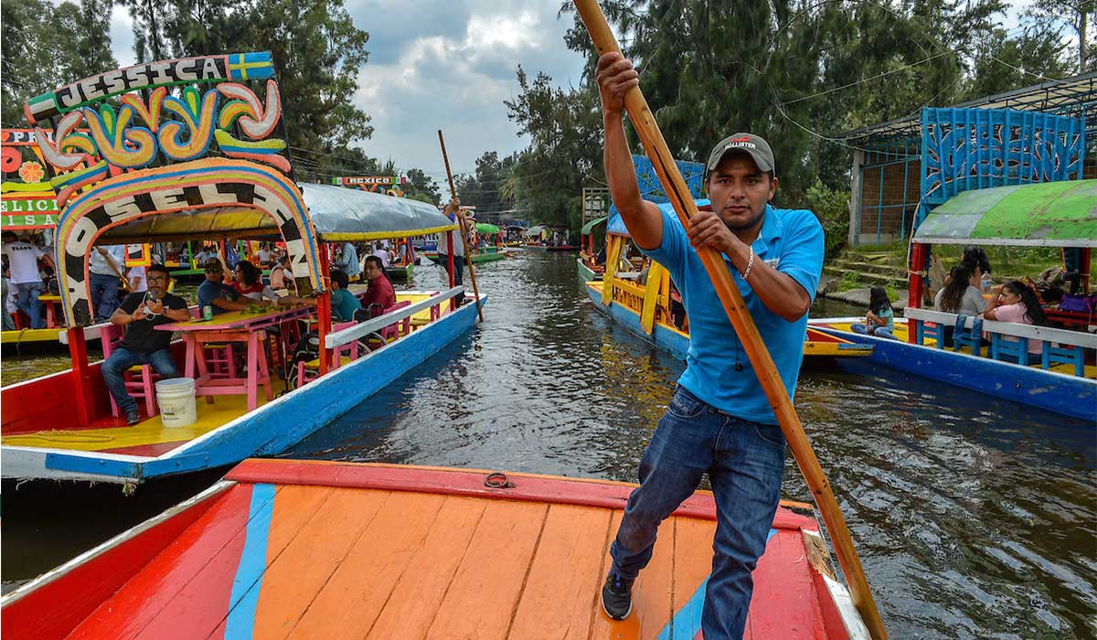 Persona remando una trajinera en Xochimilco 2022