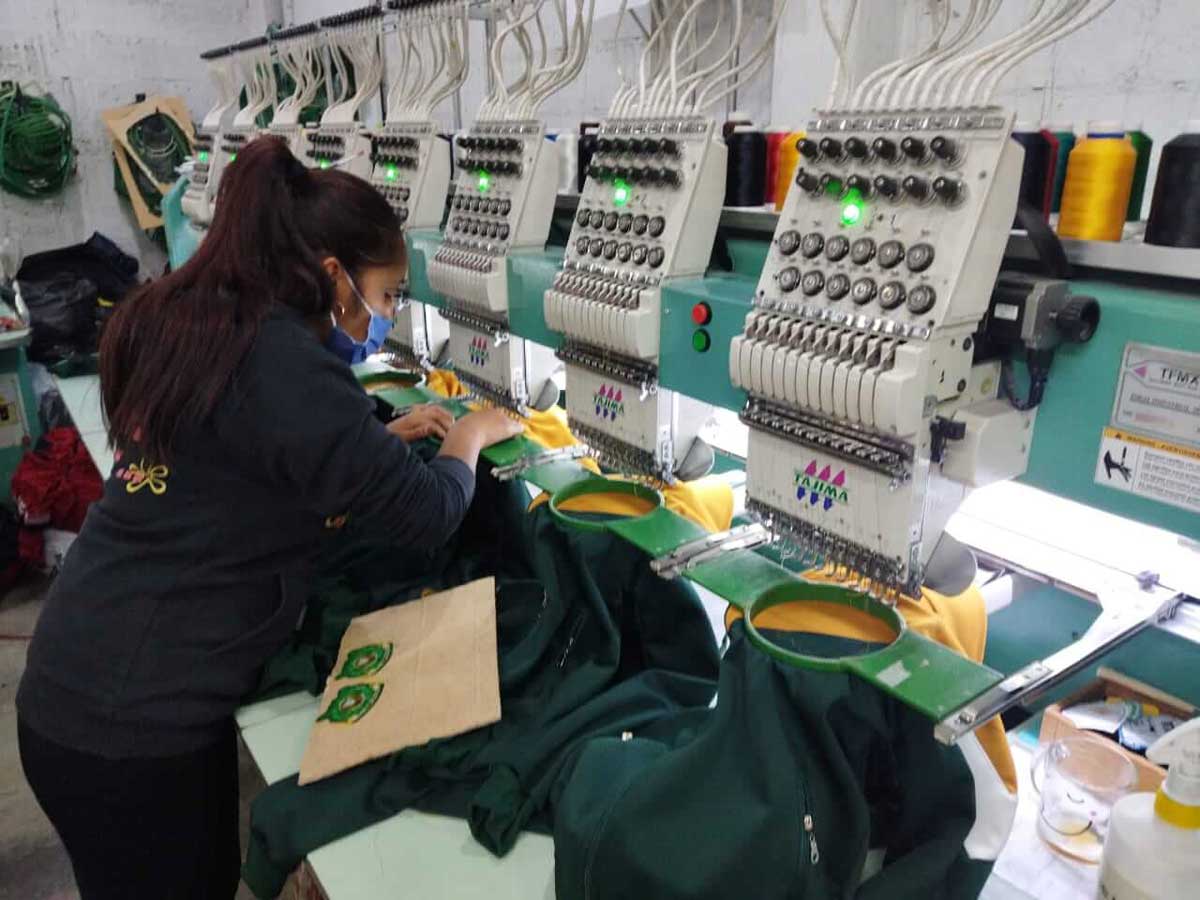 Una mujer elabora uniformes escolares en un taller familiar del municipio de Calimaya