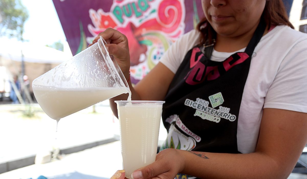 Mujer sirviendo el pulque para vender