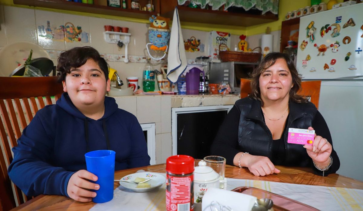 Señora e hijo mostrando la tarjeta del Salario Rosa 2023