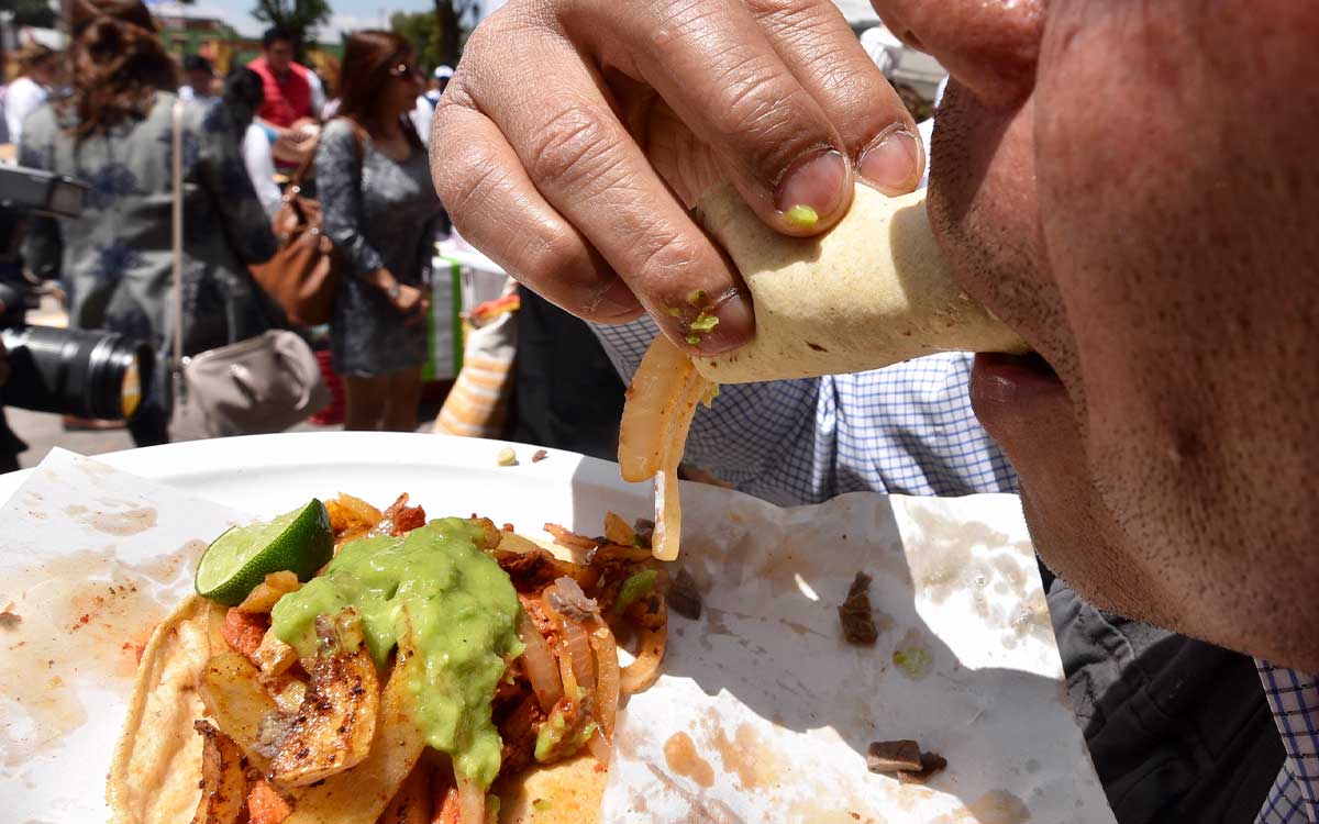 persona comiendo en la feria del taco 2023 en metepec