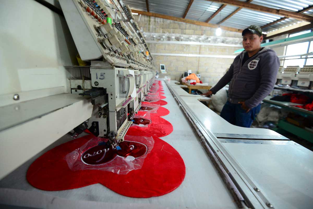 Trabajador operando tejedora industrial el Día del Trabajo