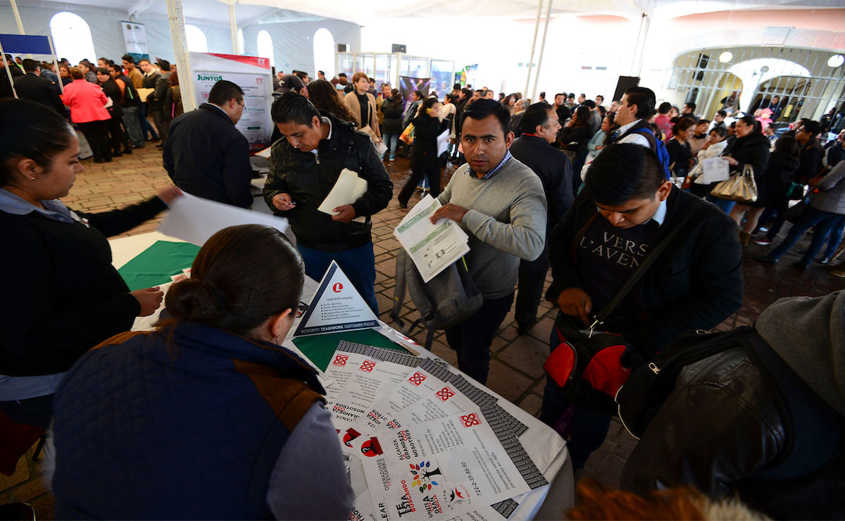 Feria del empleo, personas entregan papeles para solicitar empleo.