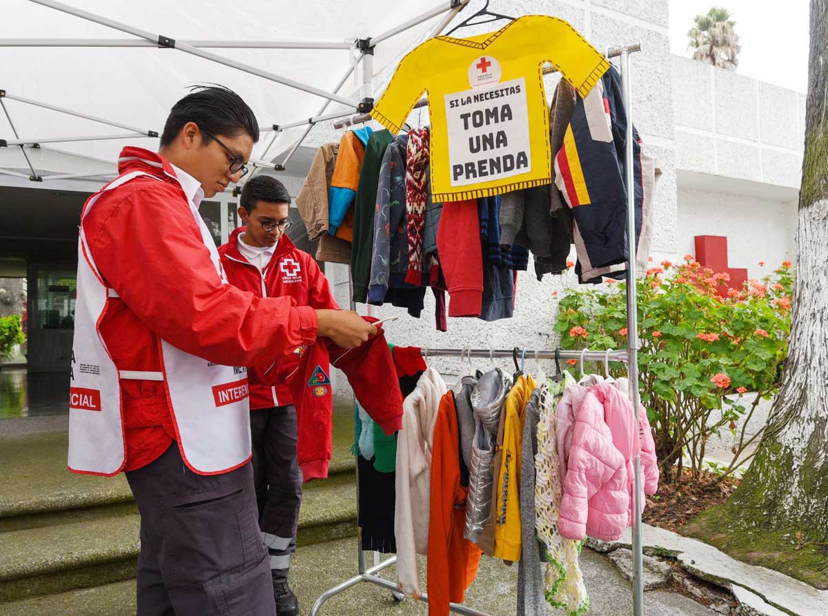 Personal voluntario de la Cruz Roja de Toluca recibe ropa de abrigo donada en el tendedero invernal