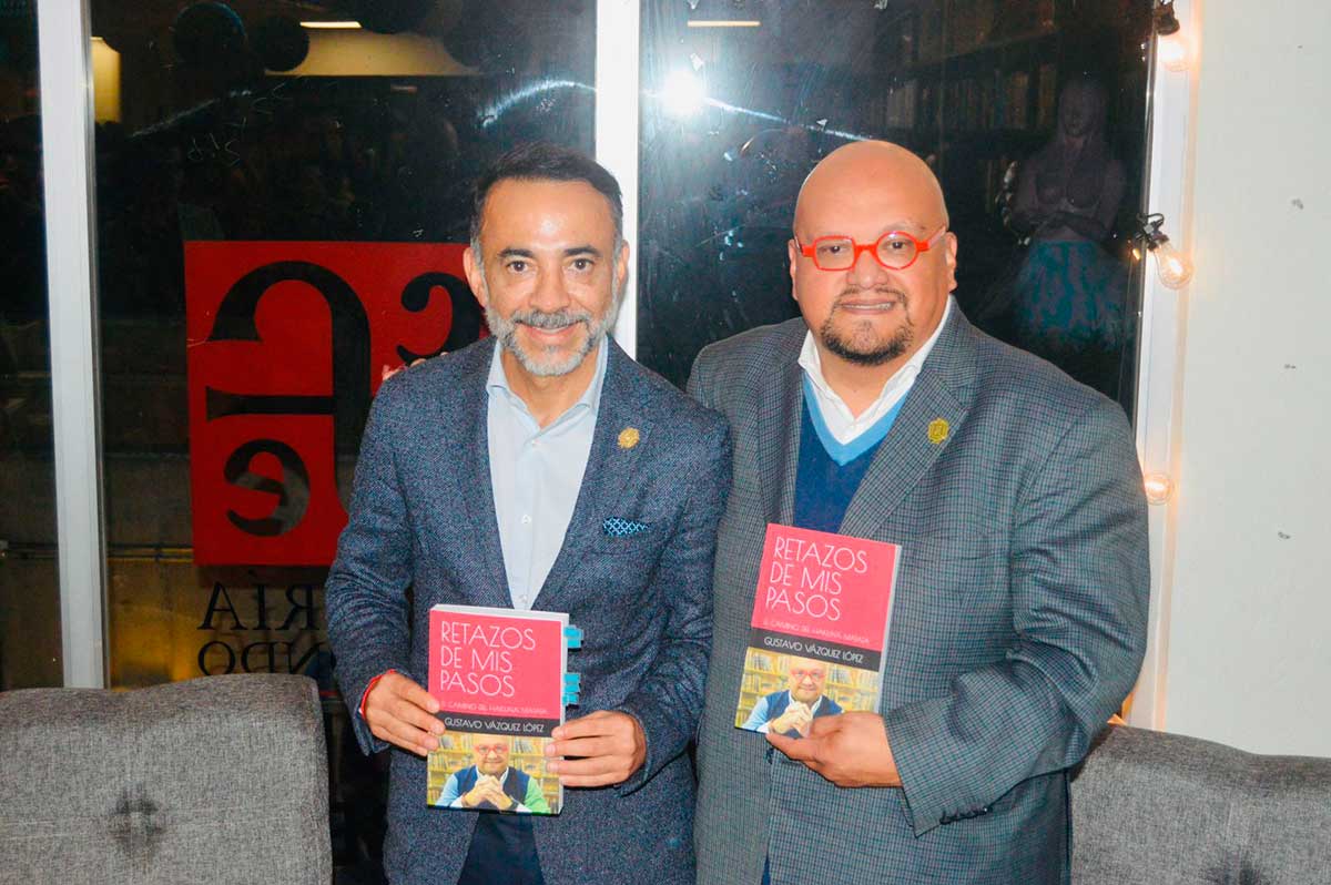 Gustavo Vázquez con el presidente municipal de Metepec Fernando Flores sosteniendo su libro debut "Retazos de mis Pasos"