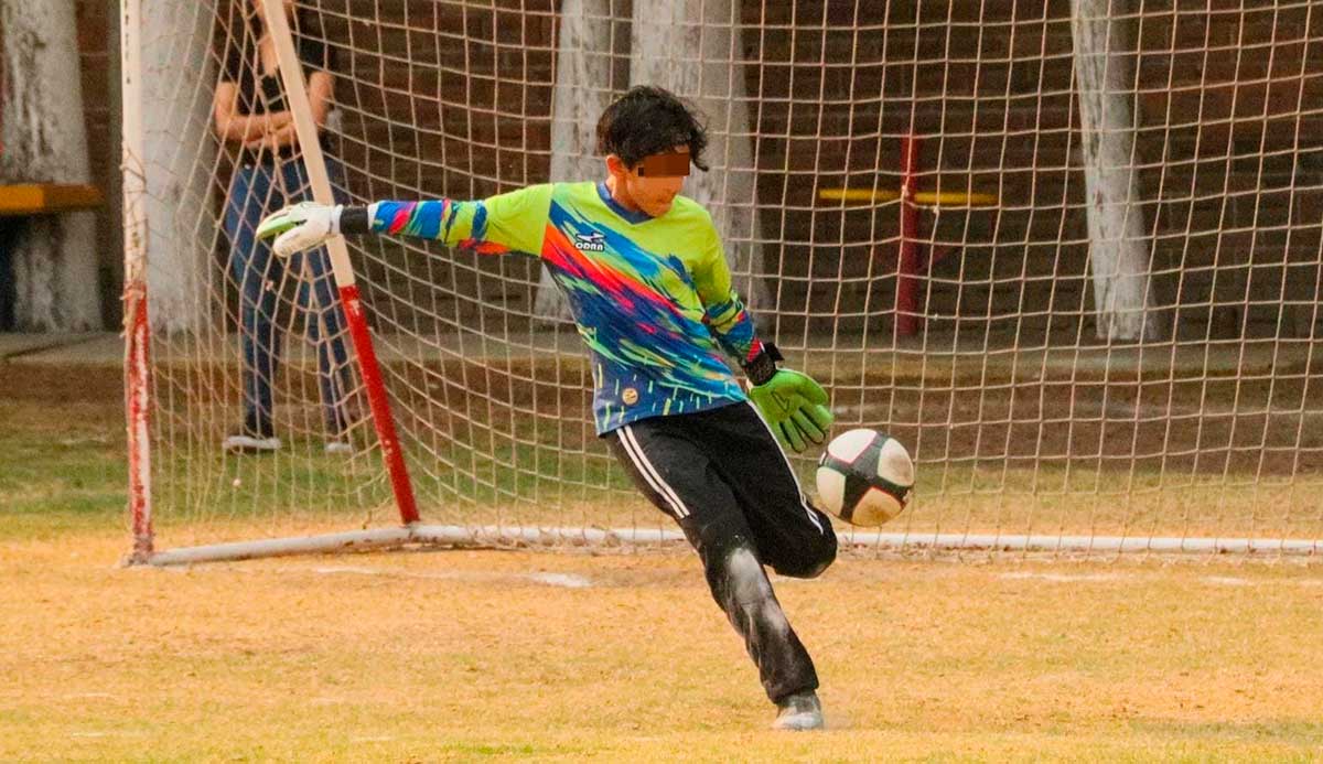Niño jugando fútbol.