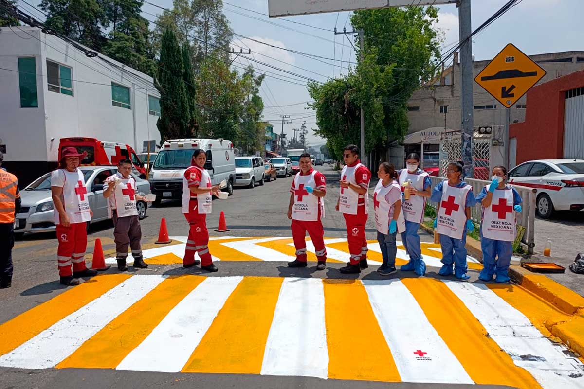 Voluntarios de la Cruz Roja señalizan calles en zonas escolares para prevenir siniestros viales.