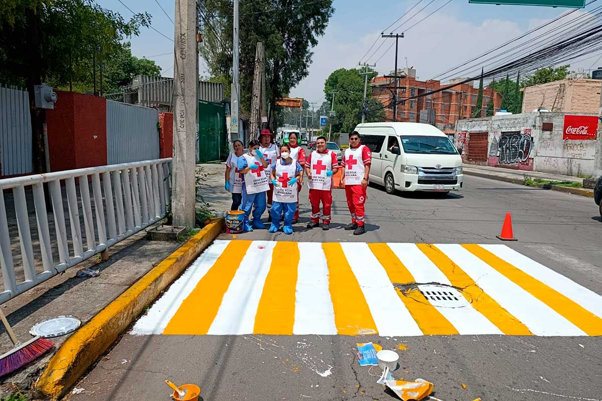 Voluntarios de la Cruz Roja señalizan calles en zonas escolares para prevenir siniestros viales.