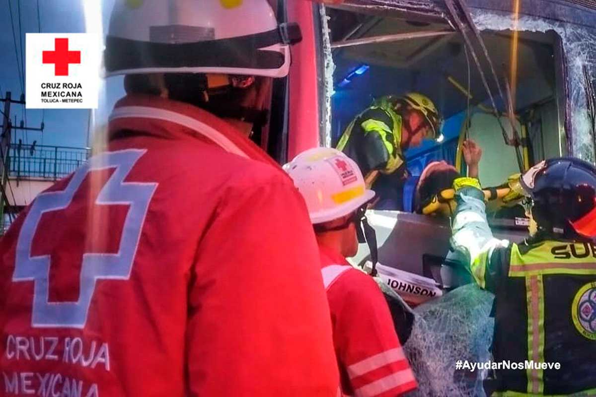 Paramédicos de la Cruz Roja atienden lesionados en el choque de dos autobuses.